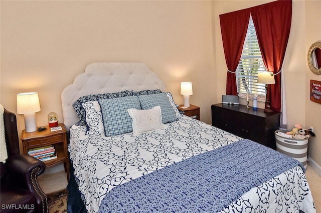 bedroom with baseboards and carpet