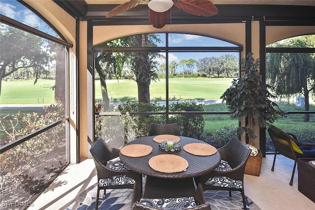 sunroom / solarium with golf course view and ceiling fan