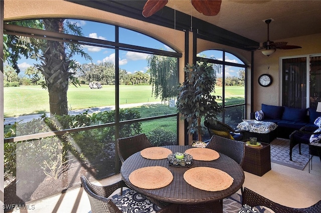 sunroom featuring outdoor lounge area, golf course view, and a ceiling fan