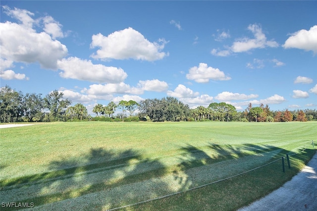 view of property's community featuring golf course view and a lawn