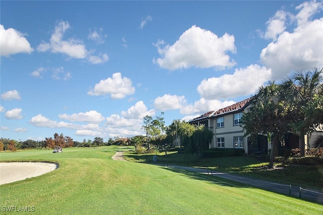 view of property's community with a yard and golf course view