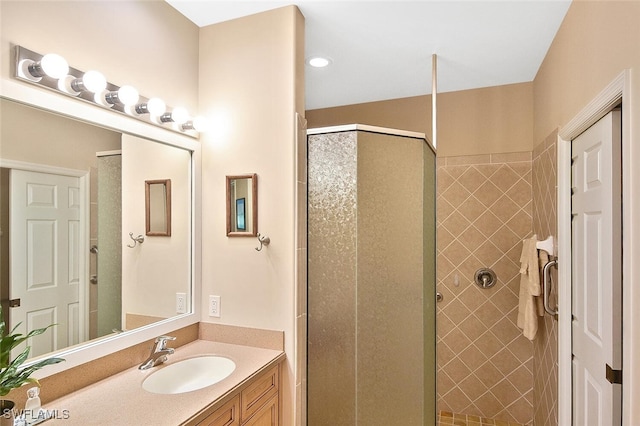 bathroom featuring a shower with door and vanity