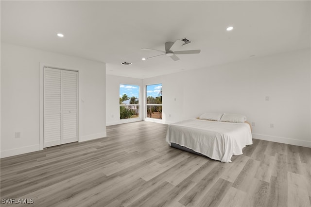 unfurnished bedroom featuring a closet, light hardwood / wood-style flooring, and ceiling fan