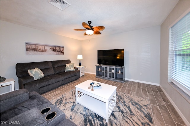 living room featuring wood-type flooring and ceiling fan