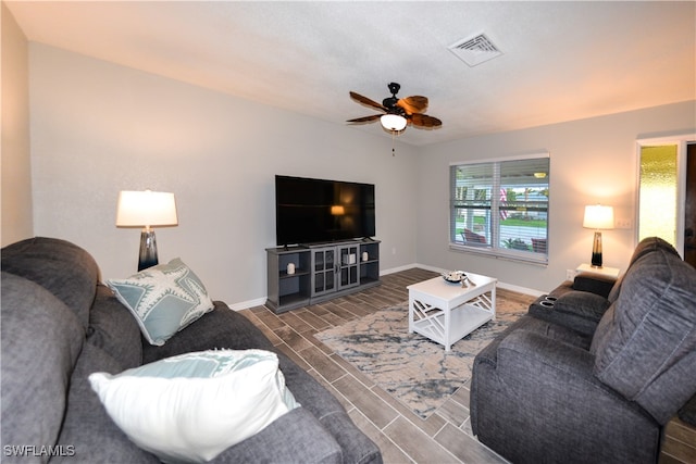 living room featuring ceiling fan and dark hardwood / wood-style flooring