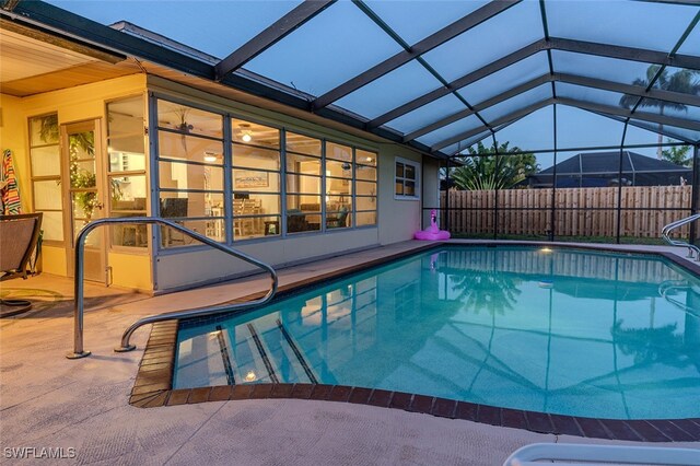 view of swimming pool with a patio and glass enclosure