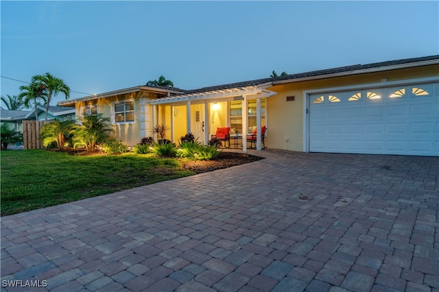 ranch-style house with a yard and a garage