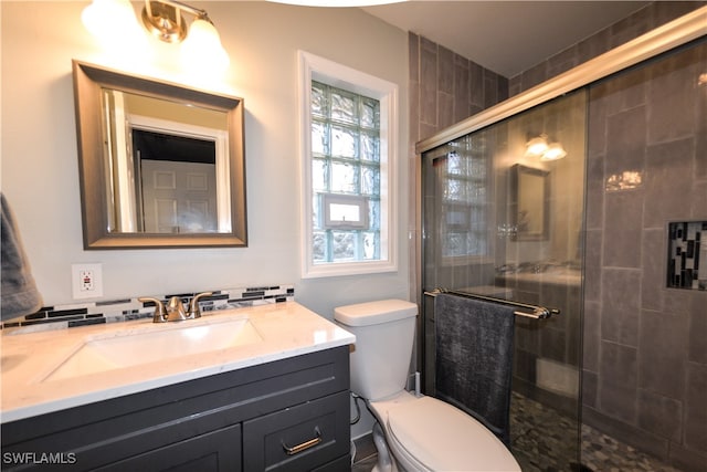 bathroom with vanity, toilet, and a shower with shower door