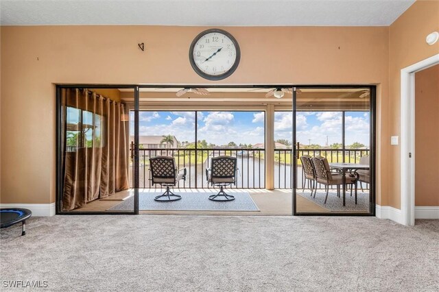 interior space featuring carpet flooring, a water view, and a healthy amount of sunlight