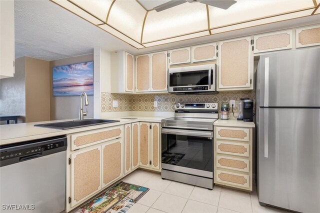 kitchen with decorative backsplash, appliances with stainless steel finishes, sink, and light tile patterned floors