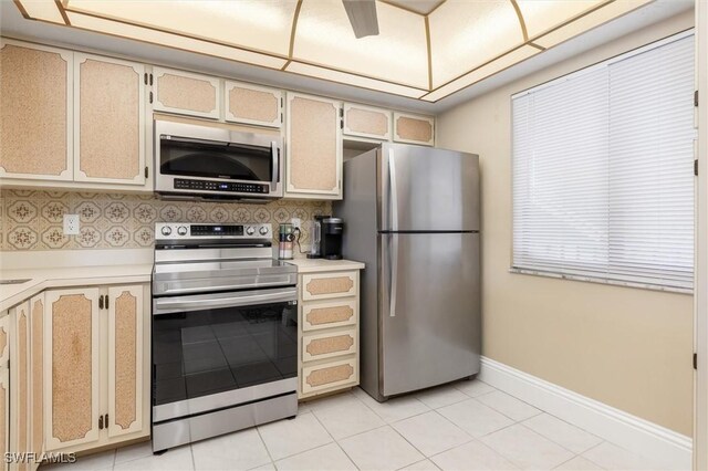 kitchen featuring appliances with stainless steel finishes, light tile patterned flooring, light brown cabinets, and tasteful backsplash