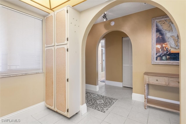 hall with light tile patterned floors