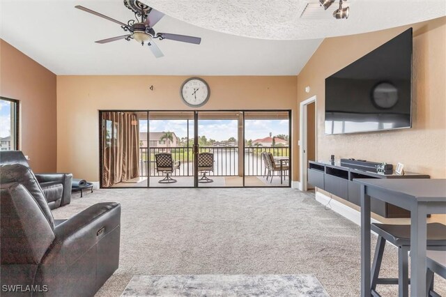 living room with light carpet, plenty of natural light, and lofted ceiling