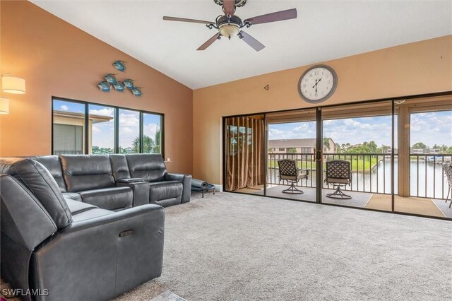 living room featuring carpet floors, a water view, and a healthy amount of sunlight