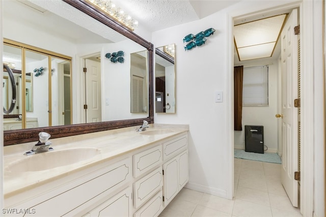 bathroom featuring tile patterned floors, vanity, and a textured ceiling