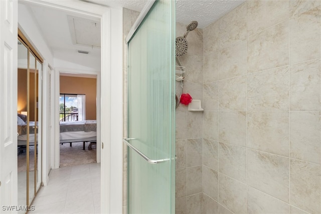 bathroom featuring a textured ceiling, an enclosed shower, and tile patterned floors