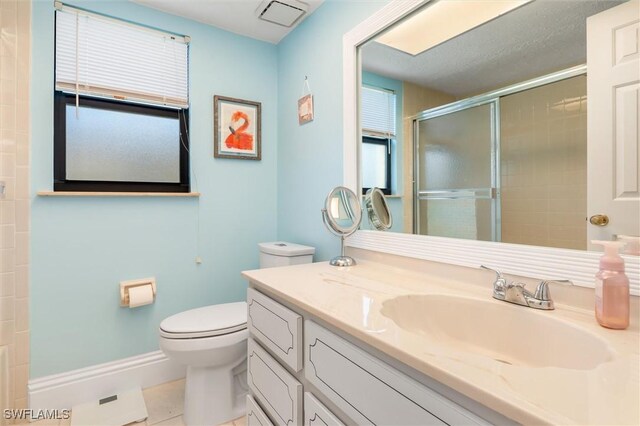 bathroom featuring toilet, tile patterned floors, a shower with shower door, vanity, and a textured ceiling