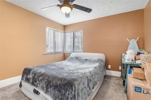 carpeted bedroom with ceiling fan and a textured ceiling