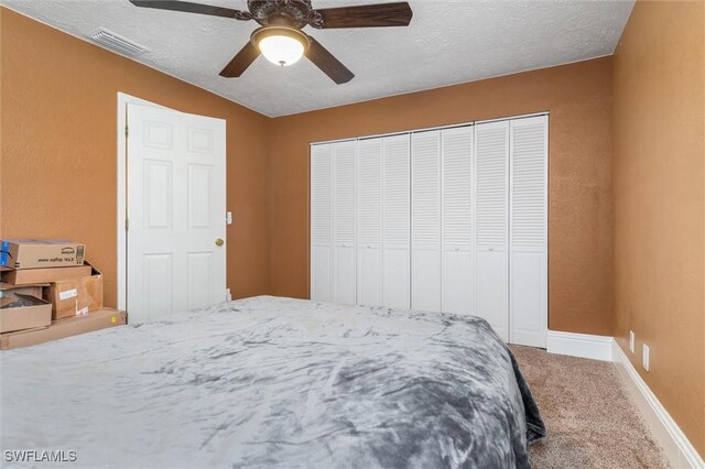 bedroom featuring ceiling fan, a closet, carpet, and a textured ceiling