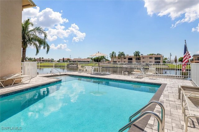 view of swimming pool with a water view and a patio area