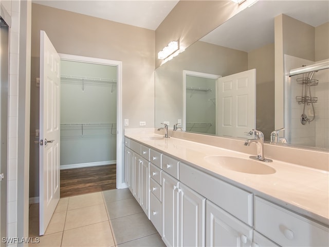 bathroom featuring tile patterned floors, walk in shower, and vanity