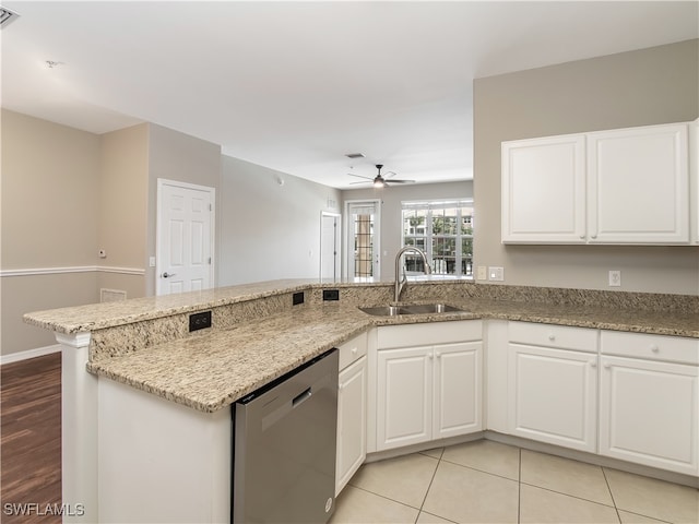 kitchen with light stone countertops, sink, kitchen peninsula, white cabinetry, and dishwasher