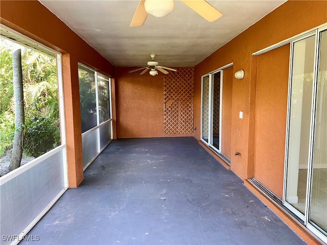 unfurnished sunroom with ceiling fan