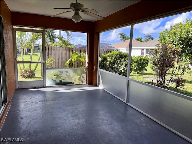 unfurnished sunroom featuring ceiling fan and plenty of natural light