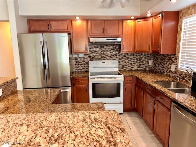 kitchen featuring stainless steel appliances, light stone counters, sink, exhaust hood, and light tile patterned flooring