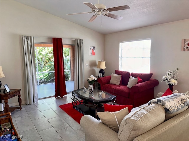 tiled living room with ceiling fan and vaulted ceiling