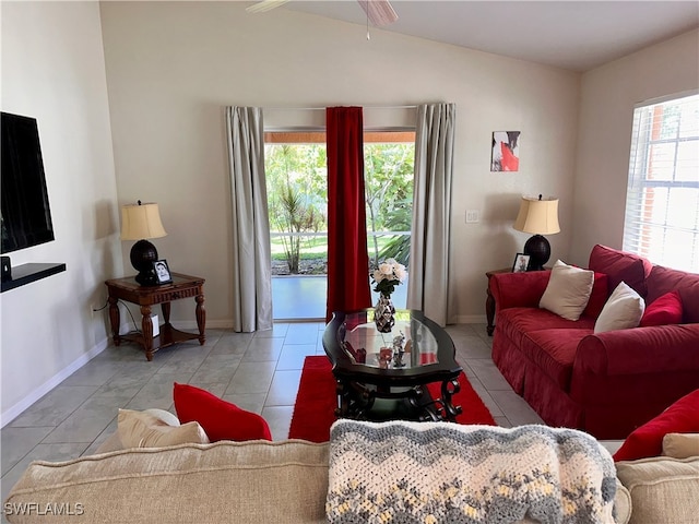 living room with a wealth of natural light, light tile patterned floors, and vaulted ceiling