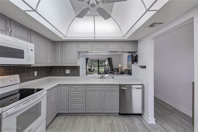 kitchen with gray cabinets, white appliances, ceiling fan, and sink