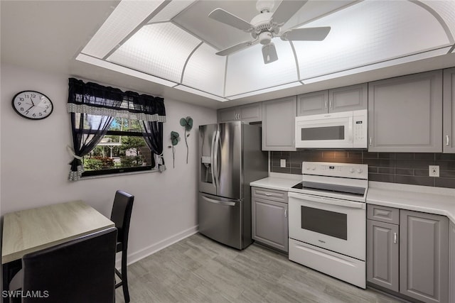 kitchen with light hardwood / wood-style floors, white appliances, and gray cabinetry