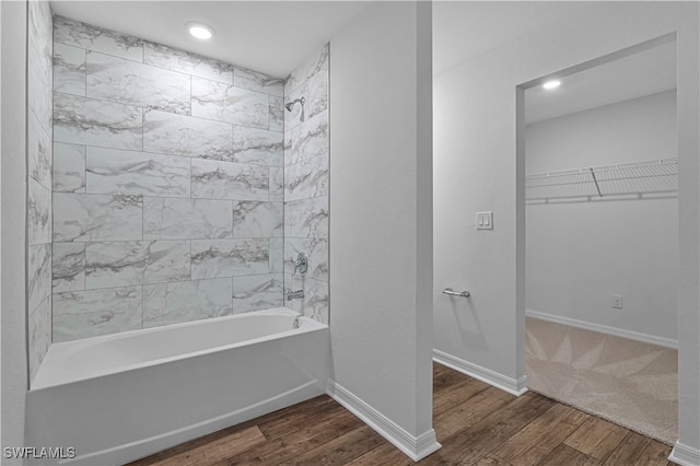 bathroom featuring wood-type flooring and tiled shower / bath