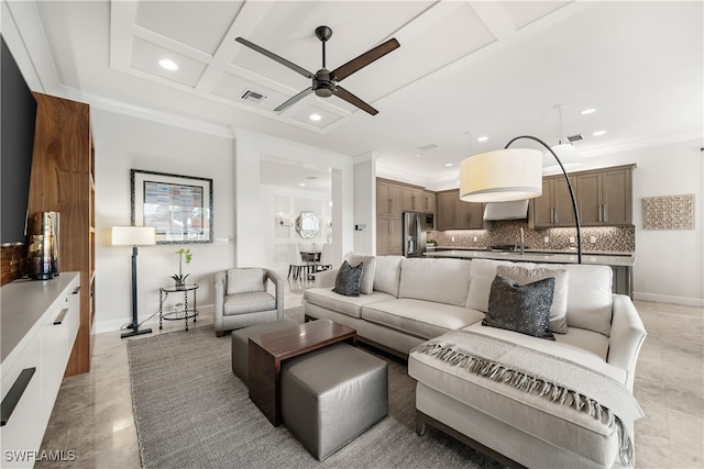 tiled living room with coffered ceiling, crown molding, and ceiling fan