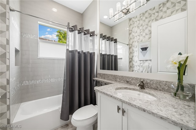 full bathroom featuring toilet, shower / bath combo with shower curtain, and vanity