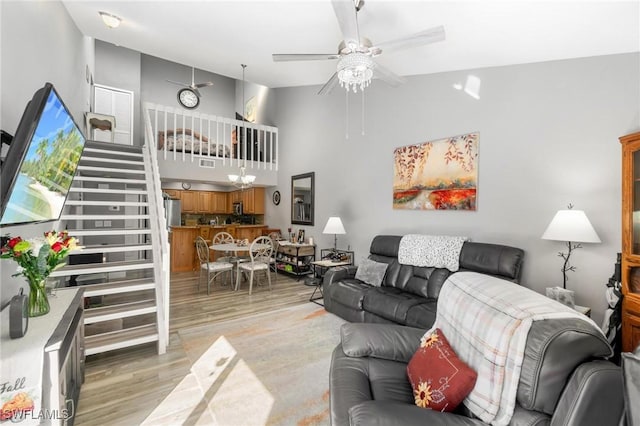 8913 Somerset Blvd, Fort Myers, FL 33919 - living area featuring light wood-style floors, stairway, a towering ceiling, and ceiling fan