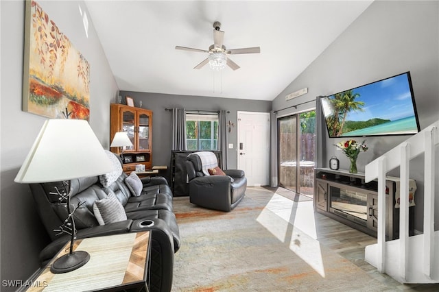 living room featuring light hardwood / wood-style flooring, vaulted ceiling, and ceiling fan