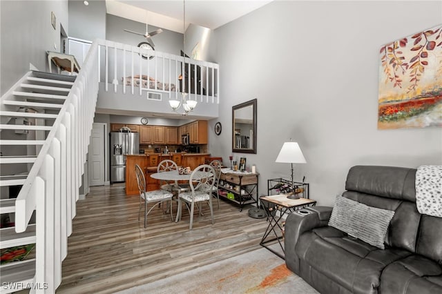 living room with hardwood / wood-style floors and a towering ceiling