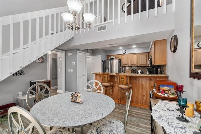 8913 Somerset Blvd, Fort Myers, FL 33919 - dining area featuring stairway, an inviting chandelier, light wood finished floors, a high ceiling, and visible vents