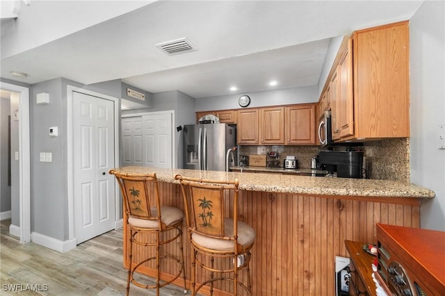 8913 Somerset Blvd, Fort Myers, FL 33919 - kitchen featuring a peninsula, light stone countertops, stainless steel appliances, and light wood finished floors