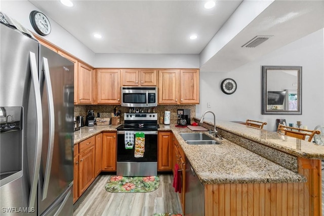 8913 Somerset Blvd, Fort Myers, FL 33919 - kitchen featuring a sink, light wood-type flooring, a peninsula, appliances with stainless steel finishes, and visible vents