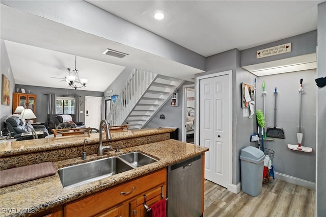 kitchen with sink, vaulted ceiling, light hardwood / wood-style flooring, decorative light fixtures, and stainless steel dishwasher