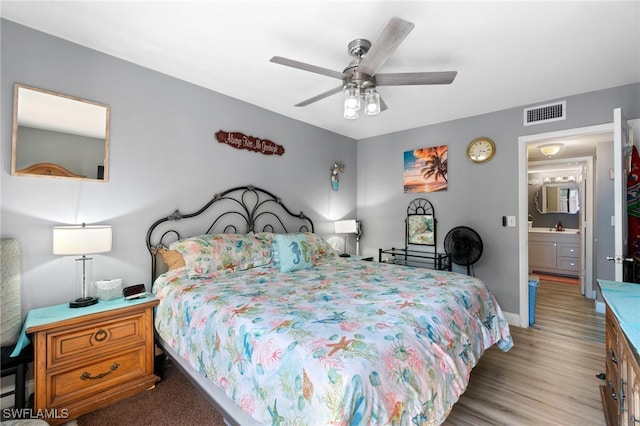 bedroom with ceiling fan, light hardwood / wood-style flooring, connected bathroom, and sink