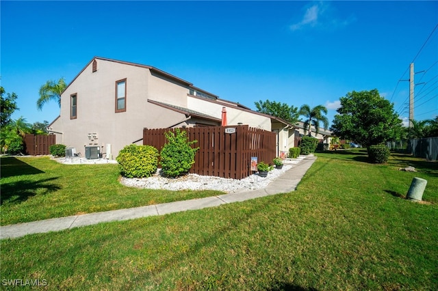 view of property exterior with a yard and central AC