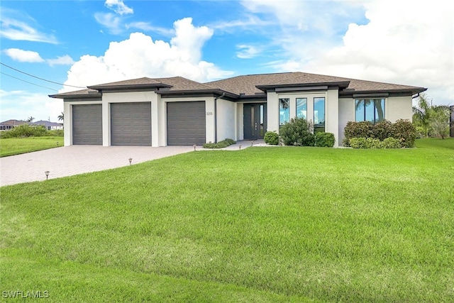 prairie-style house featuring a garage and a front lawn