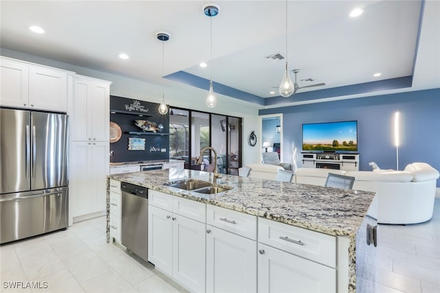 kitchen featuring a raised ceiling, sink, stainless steel appliances, and white cabinets