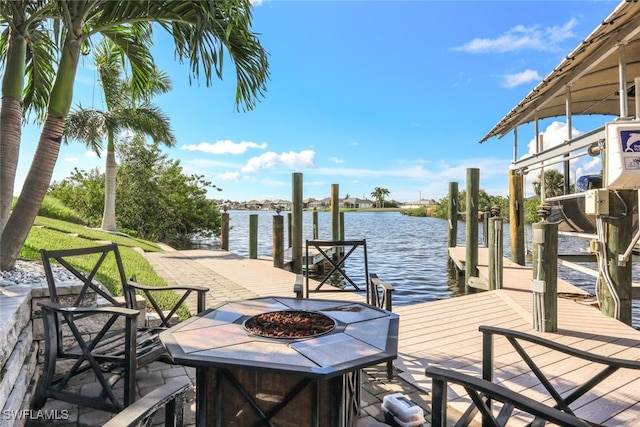 view of dock with a fire pit and a water view