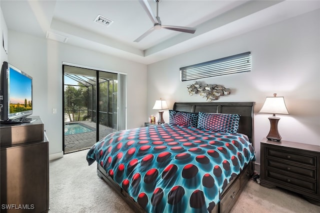 bedroom with a tray ceiling, ceiling fan, light colored carpet, and access to exterior