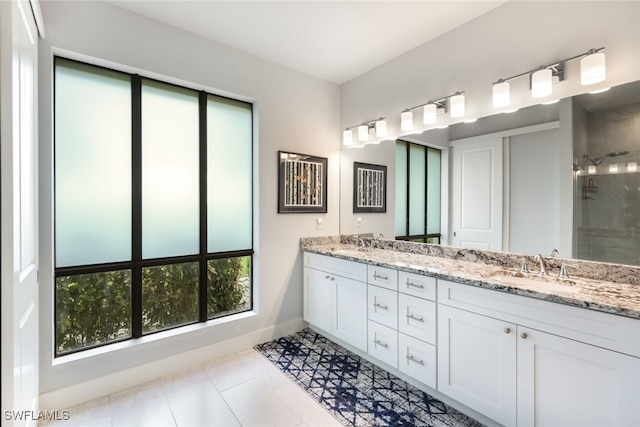 bathroom featuring tile patterned flooring, a shower with door, and vanity